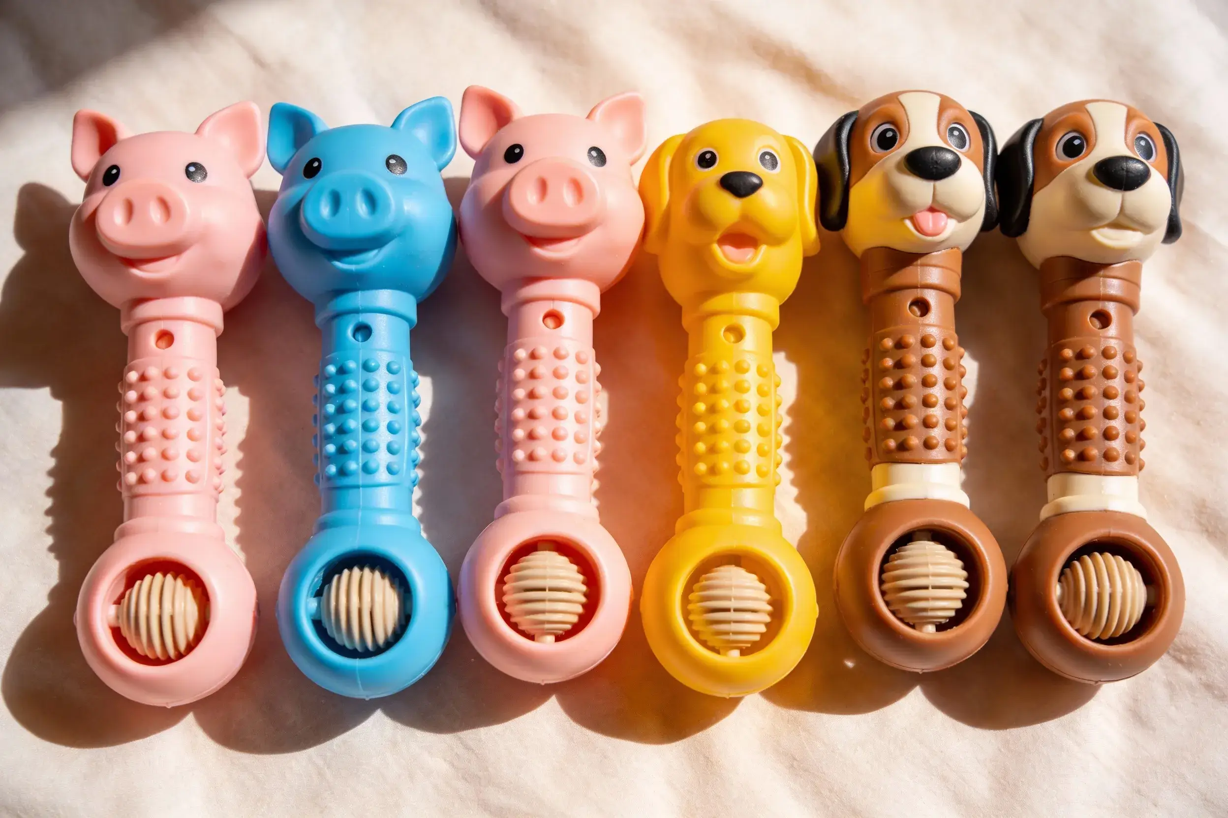 Photo of several pig dog toys, comparing squeaky vs. grunting models side by side
